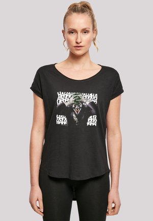 Black t-shirt featuring a graphic print of a character with a painted face, surrounded by text. Short sleeves and a relaxed, curved hem design.