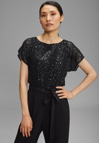 Zwarte pailletten top met een losse pasvorm, korte mouwen en een ronde halslijn, gecombineerd met zwarte broek met een gestrikte taille.