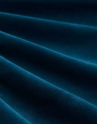 Teal ribbed fabric with soft, velvety texture, showing deep, flowing folds and a smooth sheen across the surface.