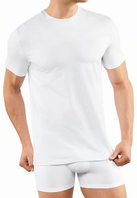White cotton short-sleeve t-shirt with a round neckline, displayed on a person wearing white boxer briefs, showcasing a fitted design.
