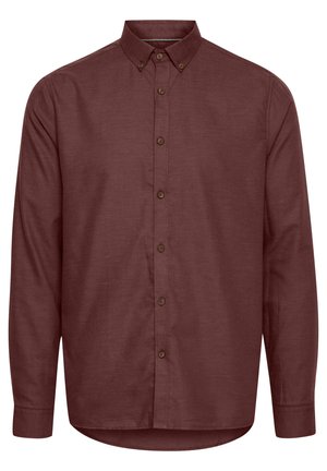 Burgundy button-up shirt with long sleeves, a pointed collar, and brown buttons. Made from textured fabric with a curved hemline.