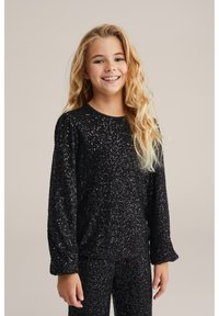 Melnā sekvīnu garām piedurknēm blūze ar apaļo kakla izgriezumu, kurai ir fakturēta virsma. Audums mirdz, pateicoties iebūvētajiem sekvīniem, kas uzlabo tā vizuālo pievilcību.