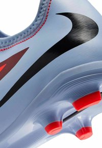 Bottines de football bleu clair avec un design noir en forme de swoosh, des accents rouges, un dessus texturé et des crampons ronds sur la semelle pour une meilleure traction.