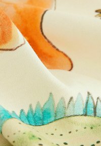 Baumwollstoff mit strukturiertem Oberflächenbild zeigt ein verspieltes Design aus orangefarbenen Formen und blau-grünen Elementen auf einem hellen Hintergrund.