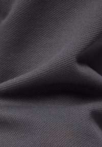 Grau strukturiertes Gewebe mit einem gerippten Muster, das eine glatte Oberfläche und ein weiches Erscheinungsbild aufweist, geeignet für verschiedene Textilanwendungen.