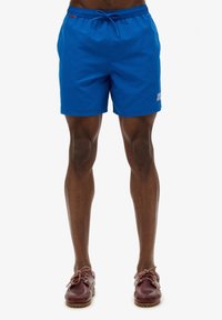 Pantaloni da bagno blu realizzati in tessuto leggero, dotati di una cintura elastica con cordino. Include un piccolo logo bianco sulla gamba sinistra.