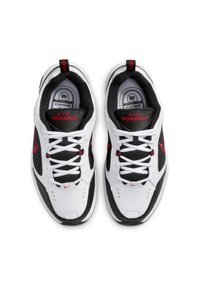 Sneakers Nike Air Monarch bianchi con dettagli neri e rossi. Presentano una tomaia in mesh, colletto imbottito e suola in gomma per trazione.