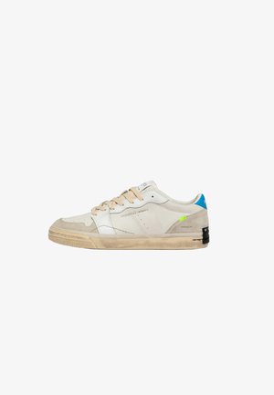 Dichtgesloten beige sneaker van suède en leer met tankleurige veters, blauwe hielstrook en licht versleten beige rubberen zool.