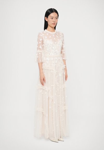 Rochie lungă, transparentă, de culoare ivoriu, cu volane suprapuse, broderie florală și mâneci clopot transparente. Guler înalt, corset croit pe corp, siluetă fluidă.