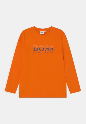 T-shirt orange à manches longues en coton, portant le texte "BOSS" en bleu et "HUGO BOSS" en plus petit en dessous. Encolure arrondie.