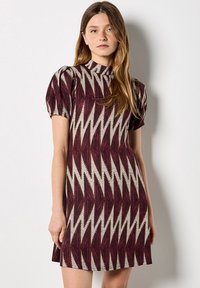 Robe à manches courtes, maroon avec un motif en zigzag beige. Dotée d'un col haut et de manches légèrement bouffantes, fabriquée en tissu texturé.