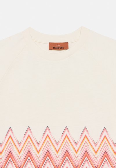 Μπεζ φούτερ με στρογγυλή λαιμόκοψη και αντίθετο ζιγκ-ζαγκ μοτίβο σε ροζ, κίτρινο και μπλε στο κάτω άκρο. Η ετικέτα γράφει "Missoni".
