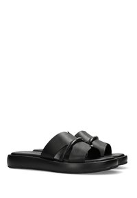 Czarne klapki na płaskiej podeszwie z szerokimi skórzanymi paskami o delikatnym połysku i designie w formie krzyżujących się pasków, osadzone na grubej, teksturowanej podeszwie.