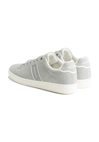 Gray suede sneakers with white rubber soles, a smooth finish, and side branding. Features round laces and padded collars for comfort.