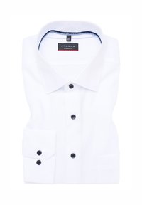 Camicia bianca con bottoni e vestibilità moderna, caratterizzata da un colletto classico, bottoni neri e una tasca sul manica sinistra.