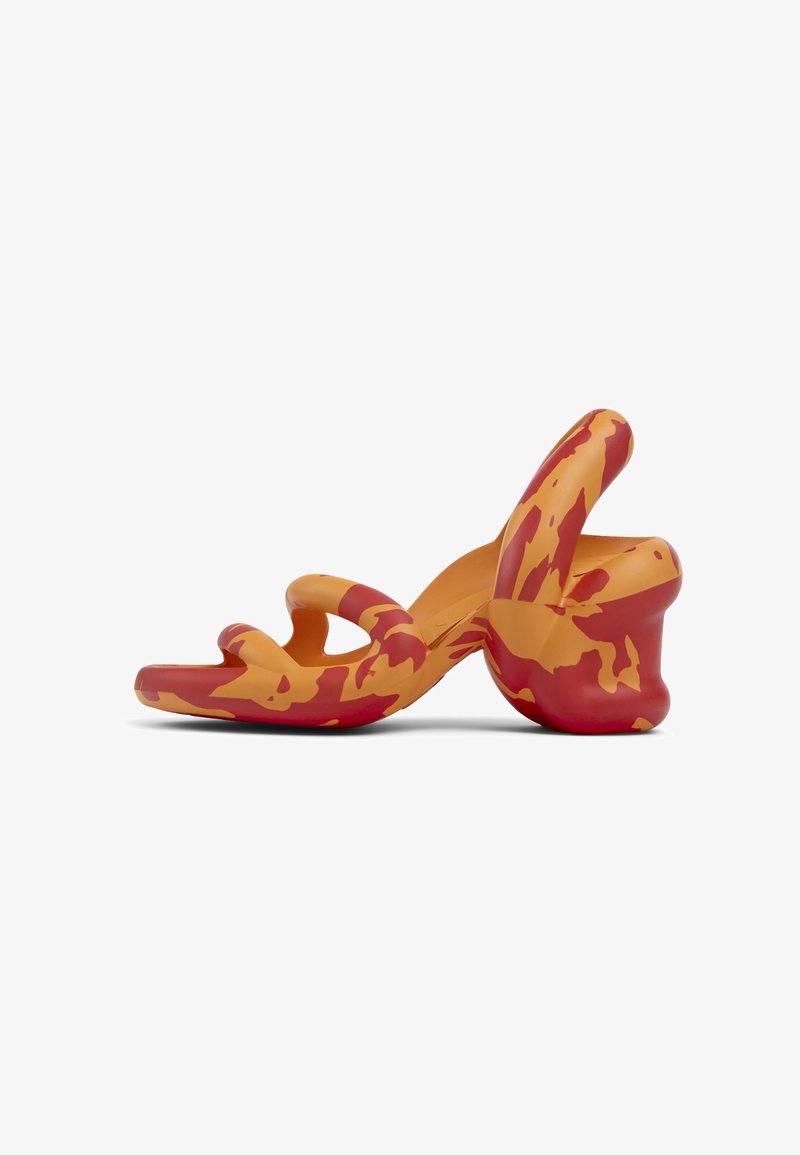 Mångfärgad sandal med en vågig design, som har orange och röda nyanser, tillverkad av ett slätt material och med en unik kurvad klackform.
