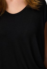 Fekete póló kerek nyakkivágással, sima textúrával és rövid ujjakkal, a szövet részleteire és minimalista dizájnra fókuszálva.