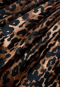 Tkanina se vzorem leopardí kůže v hnědé a černé barvě; hladká textura, s nepravidelnými skvrnami různých velikostí a tvarů.