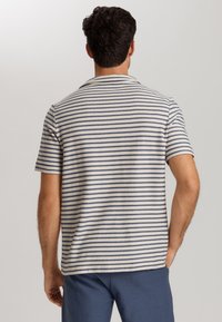 Polo in maglia a maniche corte da uomo, con righe orizzontali blu navy e bianche, tessuto testurizzato e una vestibilità rilassata con colletto classico.