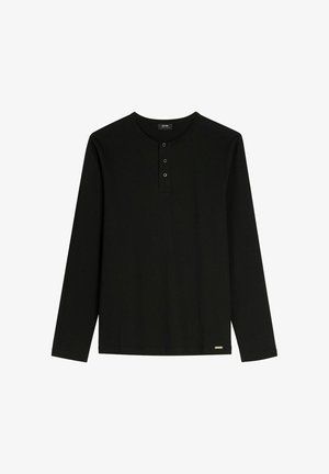 Czarna koszula z długim rękawem wykonana z miękkiego materiału, z okrągłym dekoltem, zapinana na trzy guziki, z małym metalowym logo u dołu.