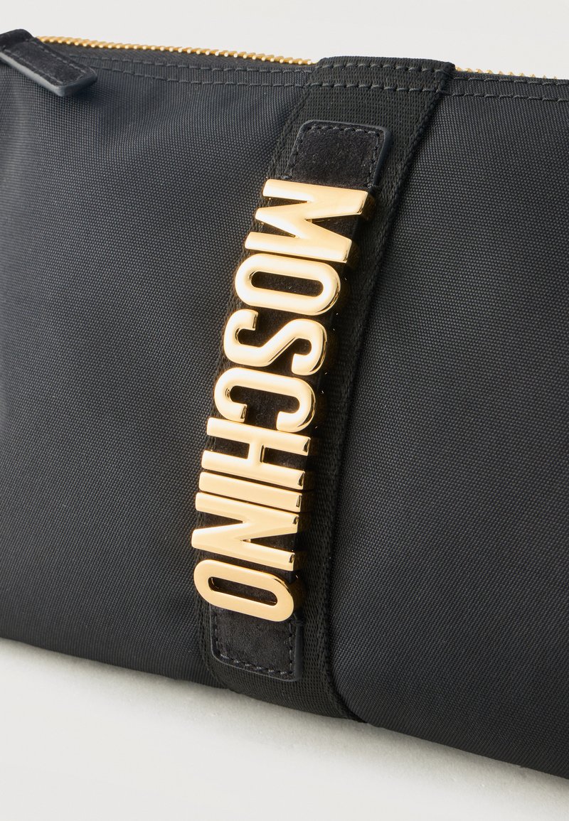 Black textured pouch with gold metal "MOSCHINO" logo vertically attached near top zipper closure.