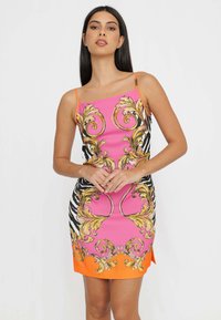 Abito rosa con intricati motivi dorati. Presenta righe bianche e nere, dettagli arancioni e spalline sottili. Design elegante e aderente.