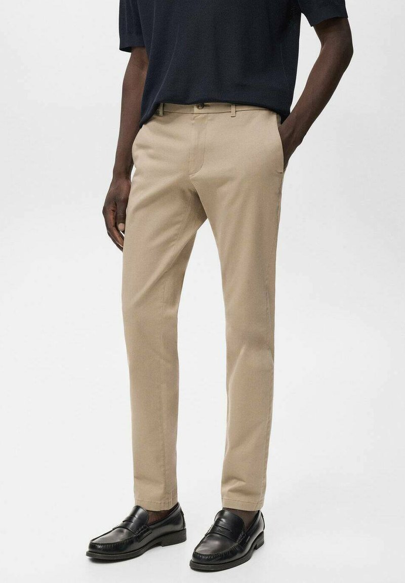 Beige tapschoenen gemaakt van zachte stof, met voorzakken, een knoopsluiting, en gecombineerd met zwarte instappers.