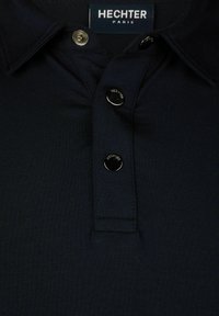 Navyblaues Poloshirt aus strukturiertem Stoff, mit klassischem Kragen, drei metallischen Knöpfen und dem Markenlabel "HECHTER PARIS."
