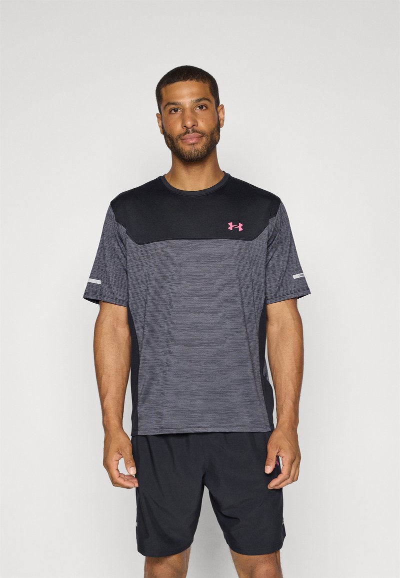 Camiseta deportiva para hombre en gris oscuro con hombros negros, mangas cortas, tejido texturizado y logo rosa en el pecho, combinada con pantalones cortos negros.