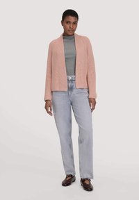 Helles rosa, geripptes Cardigan mit offenem Design. Über einem grauen Oberteil getragen, kombiniert mit hellblauen Jeans mit geradem Bein und dunklen Ballerinas.