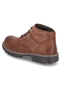 Botte en cuir marron à mi-mollet avec bout rond, design à lacets, surface texturée et semelle en caoutchouc robuste. Présente un marquage sur le côté.