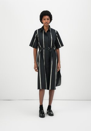 Black striped shirt dress with white vertical lines, short sleeves, belted at the waist, calf-length, and a split at the side.