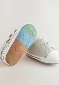 Kolorowe dziecięce buty z mieszanką miękkich, teksturowanych materiałów. Posiadają białą osłonę na palcach, wzorzysty spód i zapięcia na rzepy.