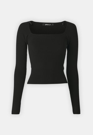 Fekete bordázott, hosszú ujjas felső négyzet alakú dekoltázzsal és testhezálló fazonnal. Puha, rugalmas anyagból készült, minimalista részletekkel.