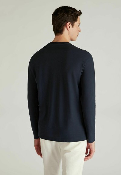 Chemise à manches longues bleu marine en tissu doux, dotée d'un col rond classique et d'une coupe décontractée, sans motifs ni accents visibles.