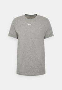 Šedé tričko s krátkým rukávem vyrobené z bavlny, s kruhovým výstřihem a bílým logem Nike na hrudi a rukávu. Hladká textura.