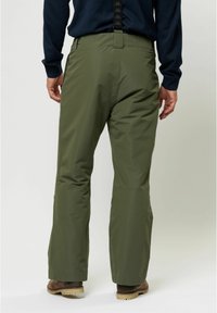 Olíva zöld, vízálló nadrág, laza fazonban, megerősített térdekkel, oldalzsebekkel és fekete, logóval díszített hófogasokkal.