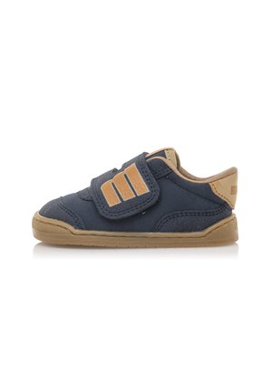 Marineblauwe peutersneakers met een klittenbandsluiting en tan accenten. Heeft een rubberen zool en een gestructureerde stoffen bovenkant voor comfort en ondersteuning.