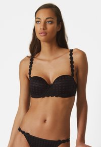 Reggiseno imbottito nero con motivo a quadri, spalline in pizzo floreale e dettagli decorativi al centro e ai bordi delle spalline. Include perizoma coordinato.