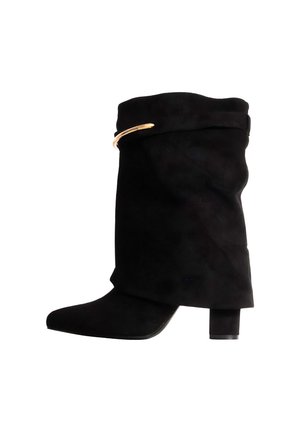 Botte haute en daim noir à la tige souple et plissée, avec un bout pointu, un talon bloc et une touche dorée au revers, sur fond blanc.
