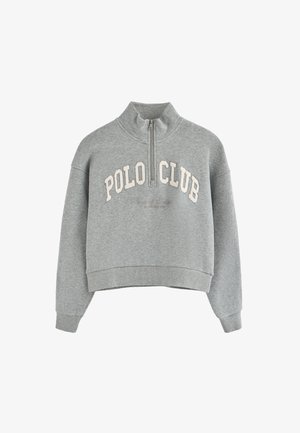 Szary polarowy sweter z wysokim kołnierzem i półzamkiem. Na przodzie znajduje się biała haftowana napisem "POLO CLUB". Krótki krój.