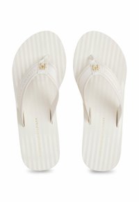 Witte gestreepte flip-flops met zachte, gekleurde banden. Bevat een klein gouden logo-accent op de band en branding op de voetbed.