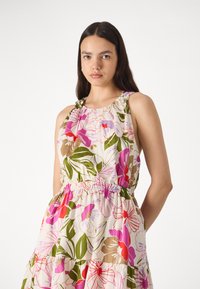 Blumenkleid mit einem hellbeigen Grundton, lebhaften Pink-, Rot- und Grüntönen, elastischem Bund, Halsband und gestuftem Saum.