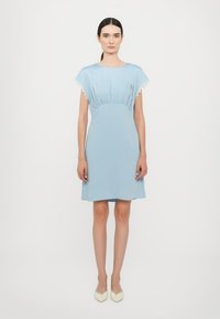 Vestido corto azul claro con un cuerpo recogido, amplias mangas cortas y borde de encaje en los hombros. Textura suave y corte a la altura de la rodilla.