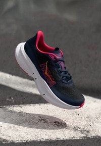 Navy running shoe with pink accents, mesh upper, cushioned white sole, and bold logo. Features intricate texture and lightweight design.