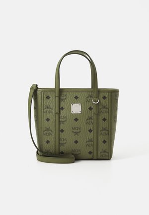 Petit sac fourre-tout en cuir vert olive avec des logos en losange noir et MCM, deux poignées, une bandoulière amovible et une plaque logo en métal au centre devant.