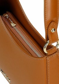 Sac à main synthétique marron avec une finition lisse, équipé de quincaillerie dorée, d'une poche zippée et d'un design structuré.