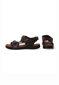 Braune Ledersandalen mit verstellbaren Riemen, offenes Zehendesign, gepolstertes Fußbett und schwarze Gummisohle, die mit detaillierten Nähten versehen ist.