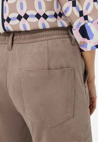 Lichtbruine suède broek met een achterzak, met een soepele textuur en een subtiele glans. De tailleband is elastisch voor extra comfort.
