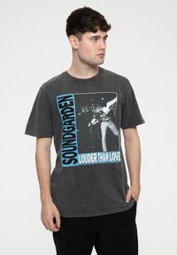 Gray cotton t-shirt featuring a large graphic print of a band with "SOUNDGARDEN LOUDER THAN LOVE" text in blue and black accents.